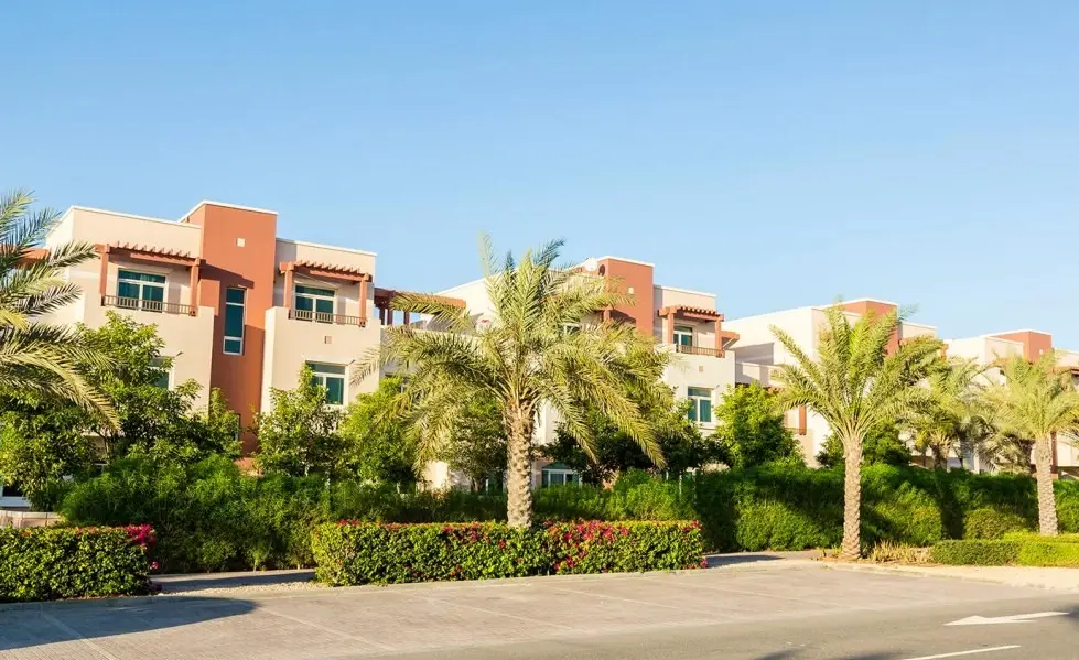 Townhouse row in Al Ghadeer Abu Dhabi, UAE surrounded by greenery and pedestrian-friendly pathways.jpg