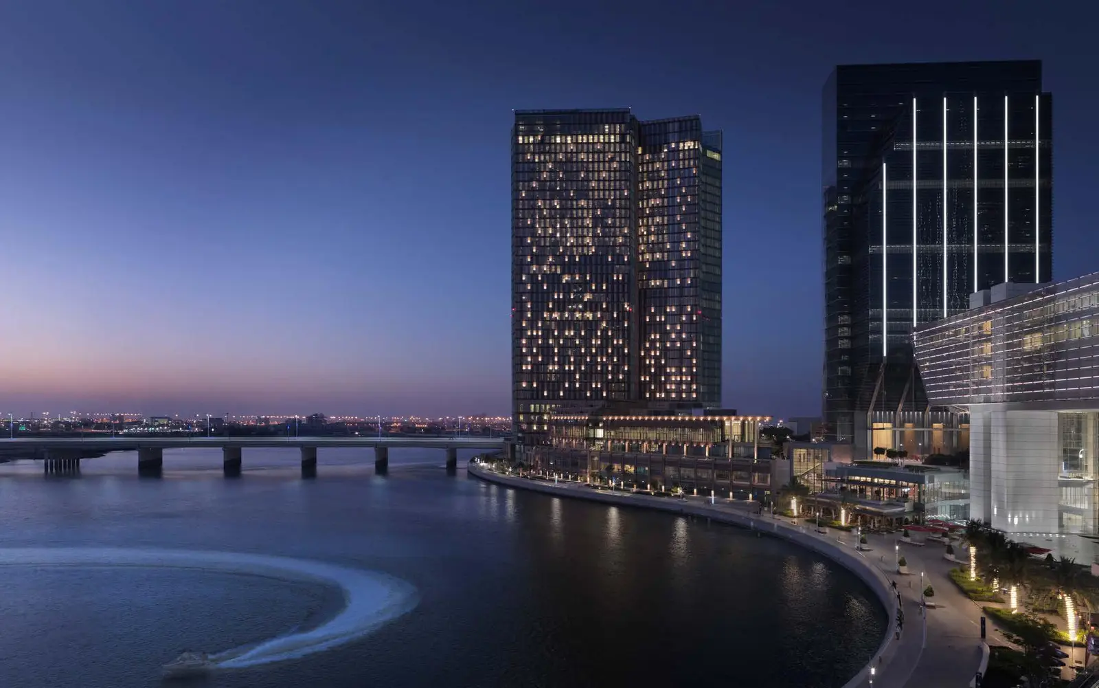 Al Maryah Island evening view with illuminated towers and waterfront reflections